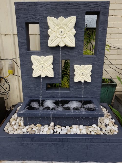 Photo of water feature wall with three flowers