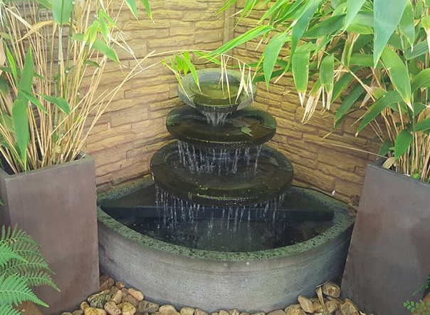 A small corner water feature consisting of cascading bowls