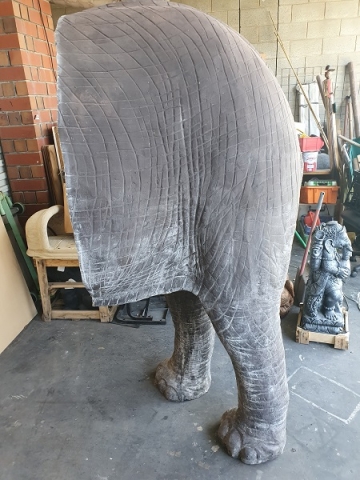 The back end of the life sized elephant standing up unsupported