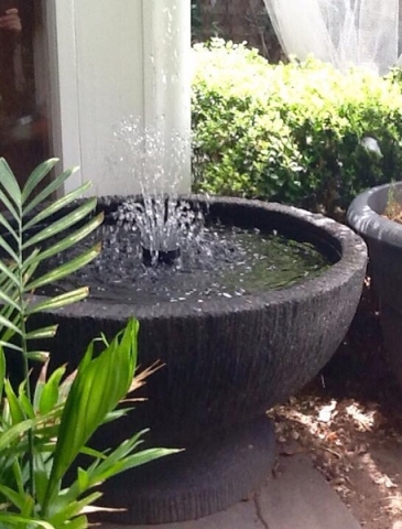 Grey ground bowl with interesting texture with a fountain head in it.