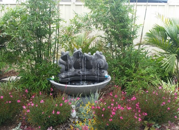 Water Feature with four frogs sitting on a bowl on a lovely garden